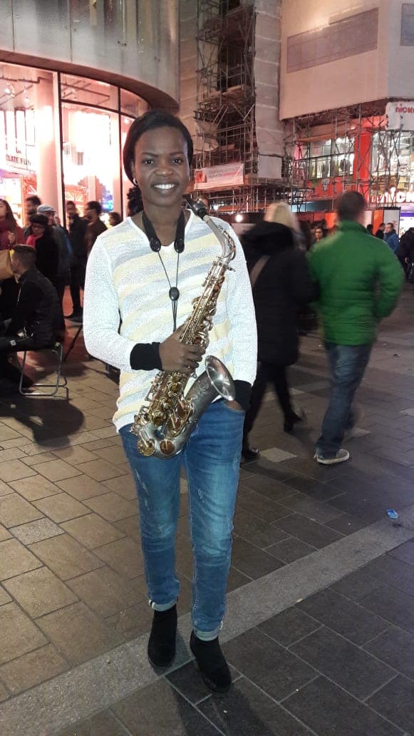 Funmisax holding her saxophone on a London street